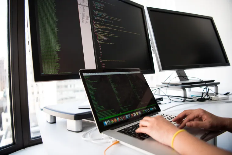 Un desarrollador de software trabajando entre varias pantallas de código